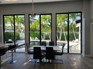 A modern room with a large window, a dining table, and chairs. - Private Newly Renovated Home - Short Walk to Beach, Food, Shopping & More!!! (Lauderdale-by-the-Sea)