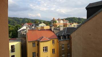 A view of a town with buildings, including a prominent yellow building with multiple windows and a red roof.