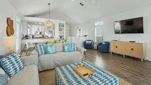 A spacious living area with a sofa set, a coffee table, and a TV mounted on the wall. - Casa Mimosa: Your Private Beach Escape with Pool, Bikes & Steps to the Sand (Santa Rosa Beach)