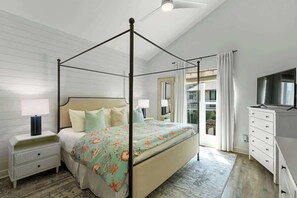 A bedroom with a four-poster bed, a nightstand, a dresser, and a television. - Casa Mimosa: Your Private Beach Escape with Pool, Bikes & Steps to the Sand (Santa Rosa Beach)