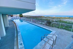 Enjoy a refreshing swim with ocean views from the pool surrounded by lounge chairs.
