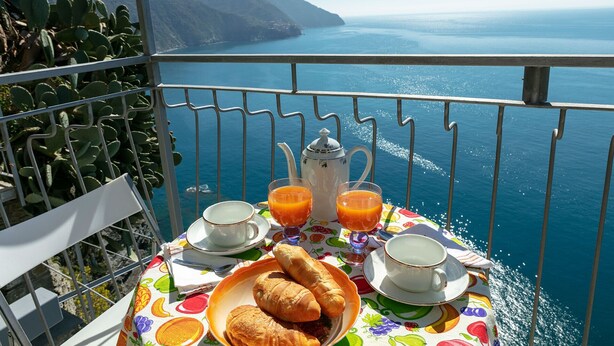 A table with breakfast items and a view of the sea.