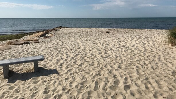 A sandy beach with footprints and a bench. - South Chatham cottage walk to beaches, dining, tennis, shops, bike path.  (Chatham)