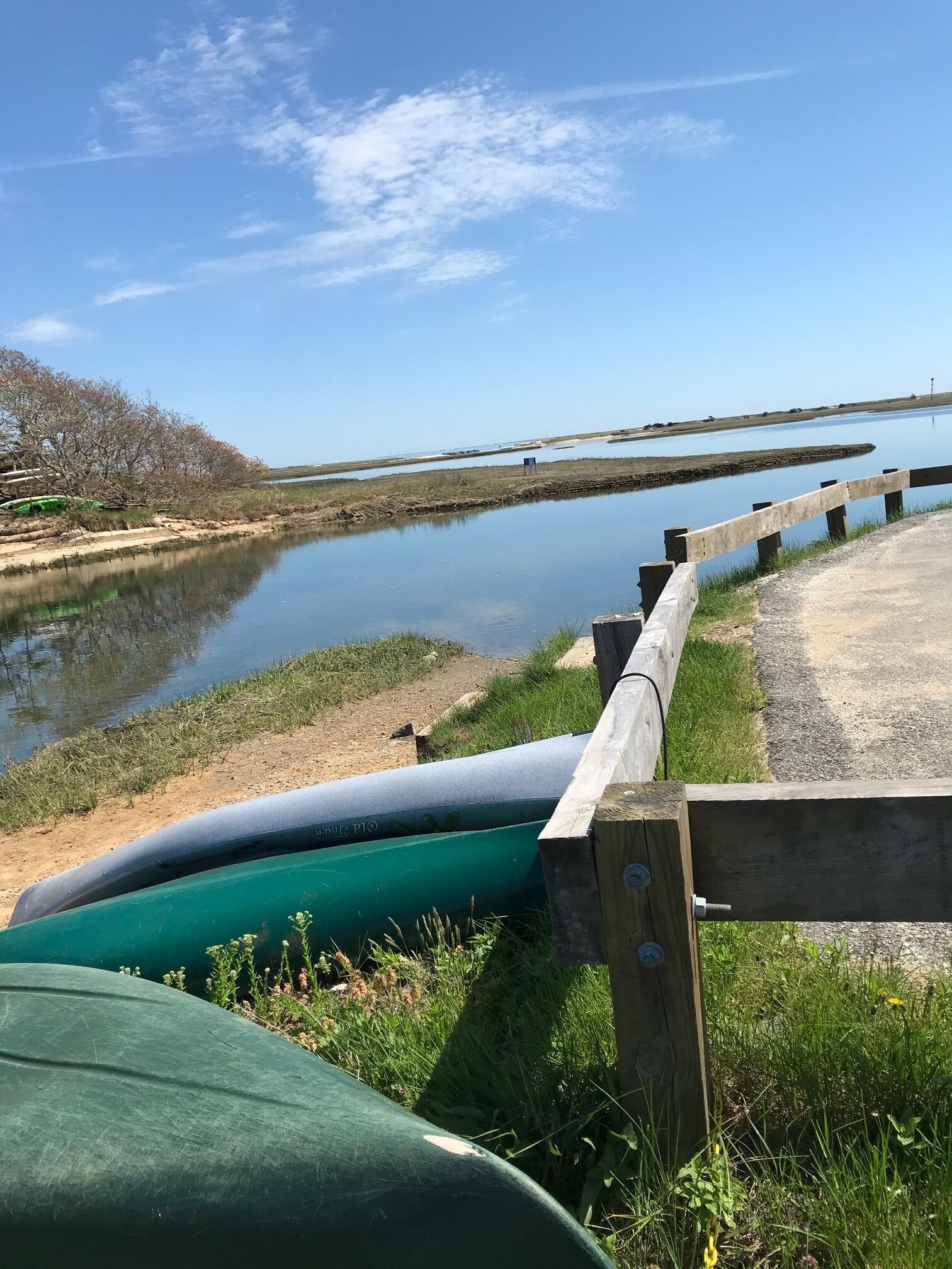 Een rustige rivier met boten, een houten omheining en een heldere lucht.