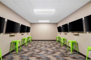 A conference room with a patterned carpet, green stools, and multiple black screens on the walls. - Sleep Inn & Suites Webb City (Webb City)