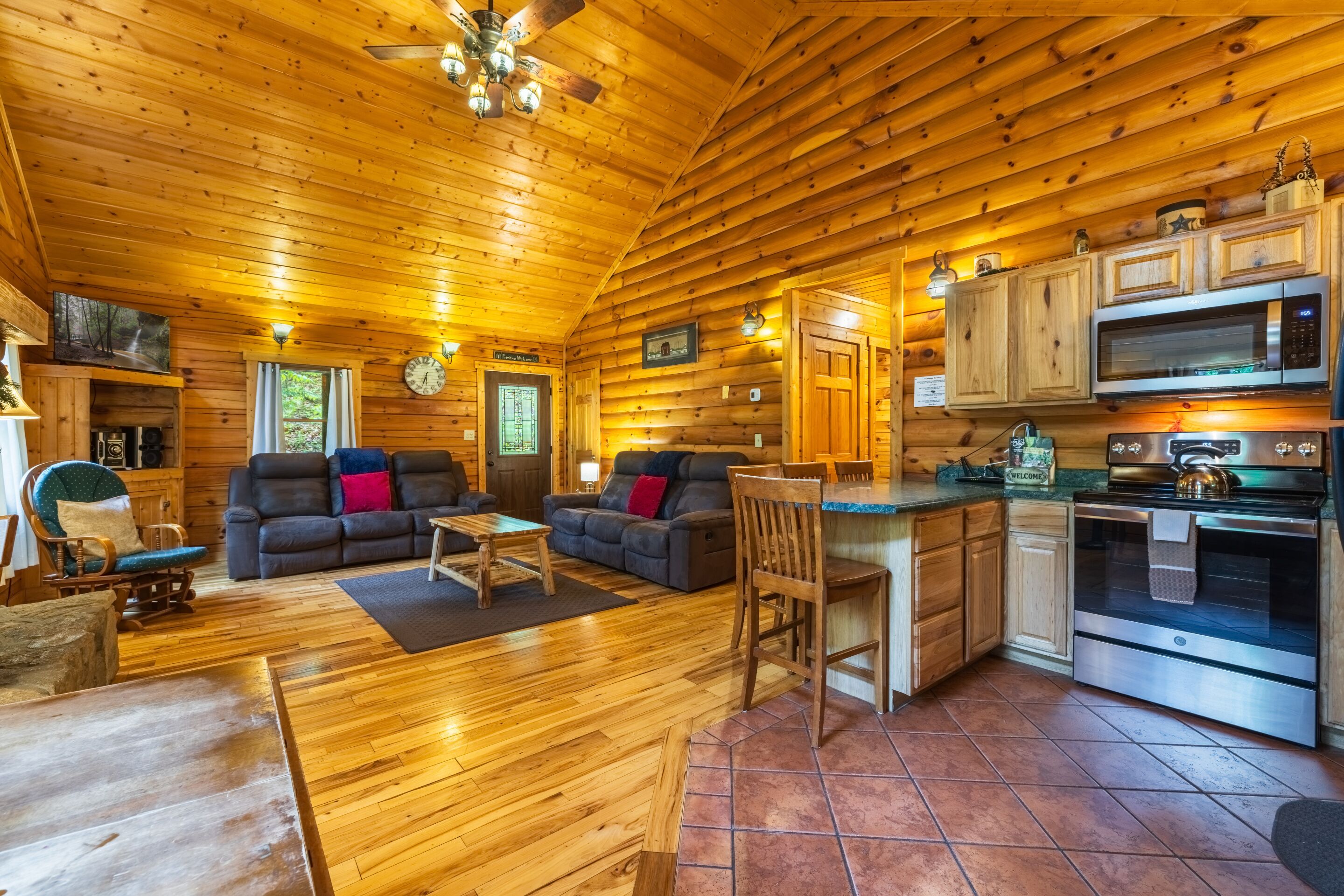 Ein Holzblockhaus-Interieur mit Wohnbereich, Essbereich und Küche, dessen Wände aus Holz bestehen.