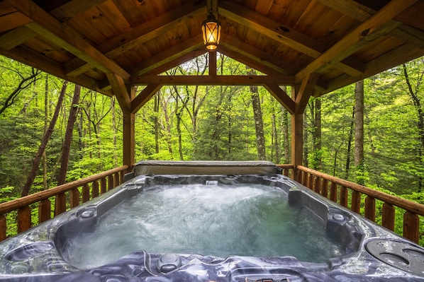 A hot tub in a wooden gazebo surrounded by a forest. - Leaning Tree - Cozy Log Cabin in the Hocking Hills (Logan)