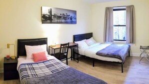 A hotel room with two beds, a desk, a chair, a lamp, and a window with curtains. - 1 #23 - 4 Bedroom Condo - McCormick Place, Wintrust Arena, Chinatown (Chicago)