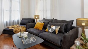 A modern living room with a dark grey sofa, a small coffee table, and a lamp. - Duplex Apartment Granada City Centre (Granada)
