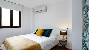A bedroom with a bed, a bedside lamp, and a window. - Duplex Apartment Granada City Centre (Granada)