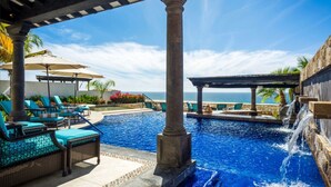 A pool area with lounge chairs, a water feature, and a view of the ocean. - <br>CHRISTMAS & NEW YEARS EVE  4 BEDROOM LUXURY RESIDENCE AT QUIVIRA LOS CABOS (Cabo San lucas)