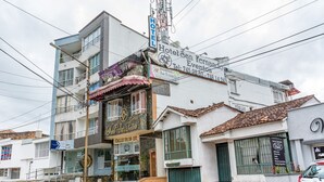 Un hotel con un cartel anunciando Hotel San Fernando Events, una entrada visible y un automóvil estacionado.