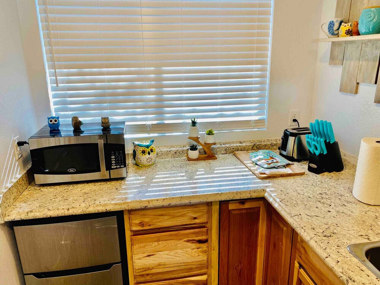 A kitchen with a microwave, toaster, and various kitchen utensils.