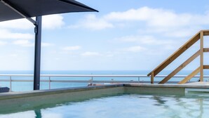 En pool med fri utsikt över havet och ett trädäck.