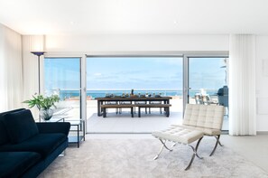 A modern living room with a large sliding glass door leading to a balcony with a view of the sea. - The Penthouse - Private heated pool and terrace with a view of the sea (Nazaré)