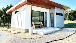 Ein modernes Einfamilienhaus mit Satteldach, großen Fenstern und einer Holzterrasse.