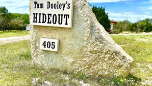Ein großer Felsen mit einem Schild, auf dem 'Tom Dooley's HIDEOUT 405' steht.
