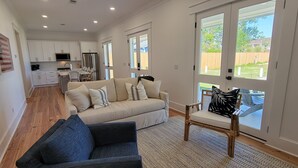 Un vaste espace de vie comprenant un canapé, un fauteuil et une table à manger.