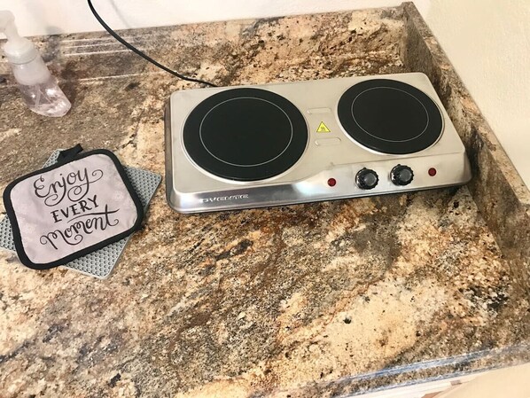 A kitchen with a double induction cooktop on a granite countertop.