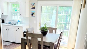 A modern kitchen with white cabinets, a sink, and a window. - 2 bedroom ranch 1 bath situated in West Yarmouth (Yarmouth)