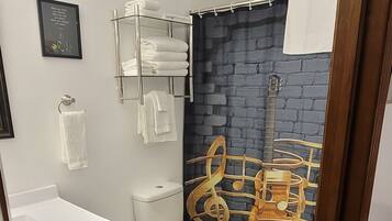 Een bad/douchecombinatie, een haardroger, handdoeken, zeep