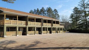 A multi-story equestrian building with multiple stables and a covered outdoor area.
