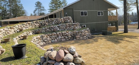 A large building with a stone retaining wall and a wooden deck.