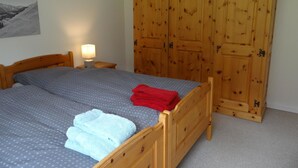 A bedroom with a bed, a nightstand with a lamp, and a wooden wardrobe. - Erlenrain Wohnung 722E Appartement/Fewo 2-Bettwohnung by Interhome (Engelberg)