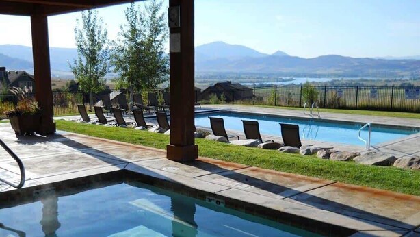 Una piscina con sillas de descanso y vistas a montañas.