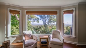 A room with two armchairs facing a large window with a view of trees and mountains. - Big Canoe Home with Mountain Views, Game Room, Fire Pit, Sleeps 14 (Big Canoe)