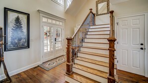 A grand staircase with wooden railings and a white door at the top. - Big Canoe Home with Mountain Views, Game Room, Fire Pit, Sleeps 14 (Big Canoe)