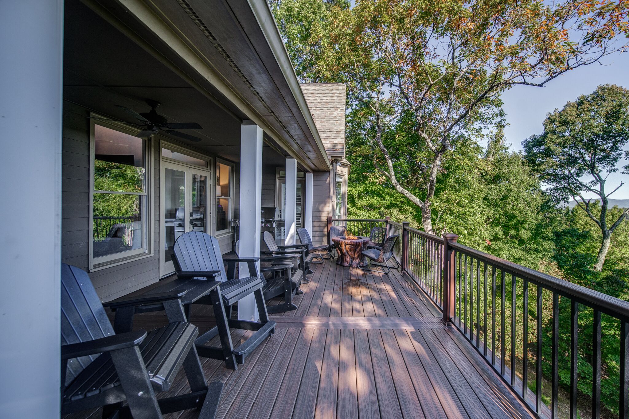 Une terrasse en bois avec des sièges, une table et une rambarde.