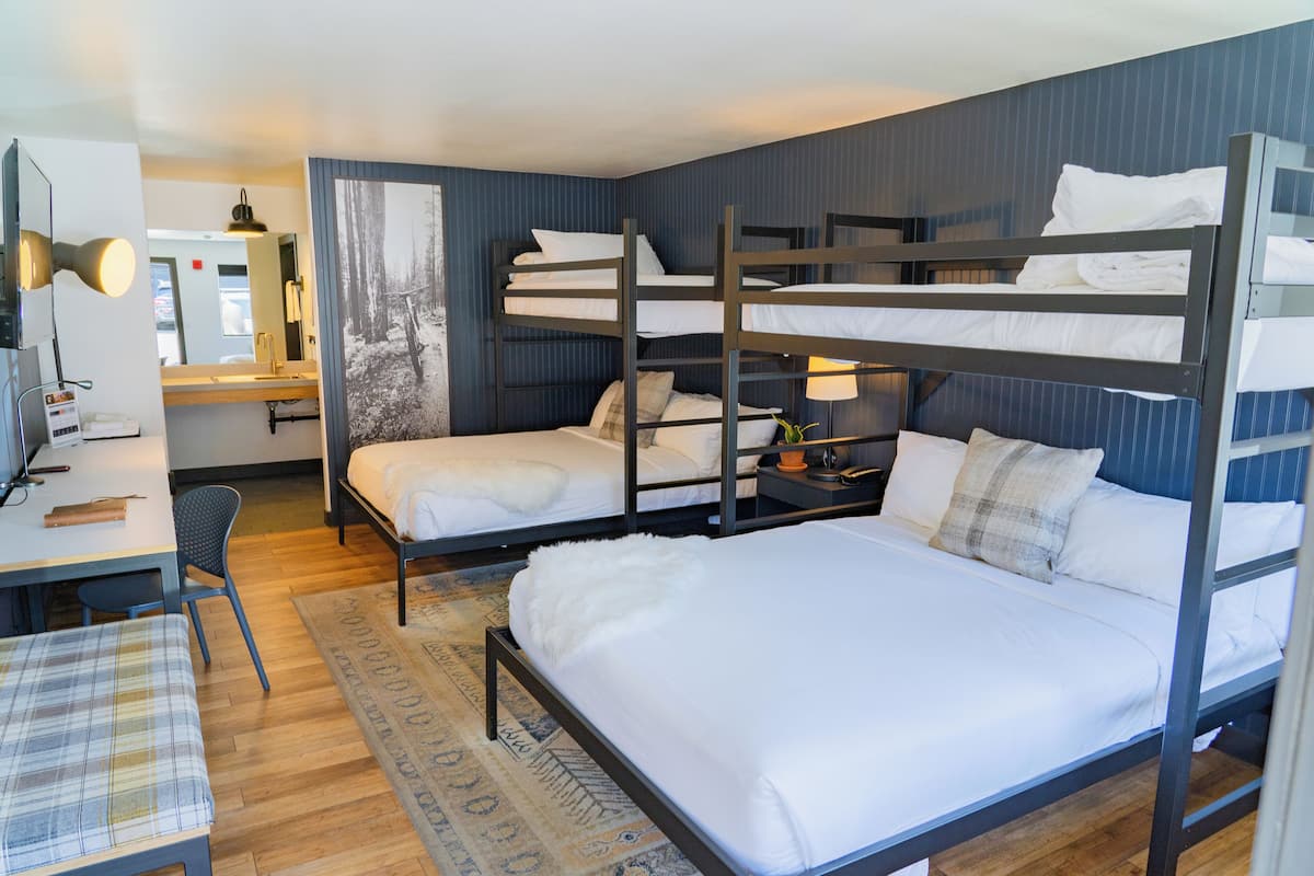 Une chambre avec un lit superposé, un bureau, une chaise et un miroir.