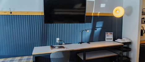 Une chambre moderne équipée d’un bureau, d’une chaise et d’un téléviseur fixé au mur.