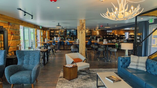 Ein moderner Aufenthaltsbereich mit Sitzgelegenheiten, einer Bar und einer Treppe.