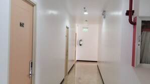 Un pasillo con una puerta identificada con el número 504 y una señal de salida.