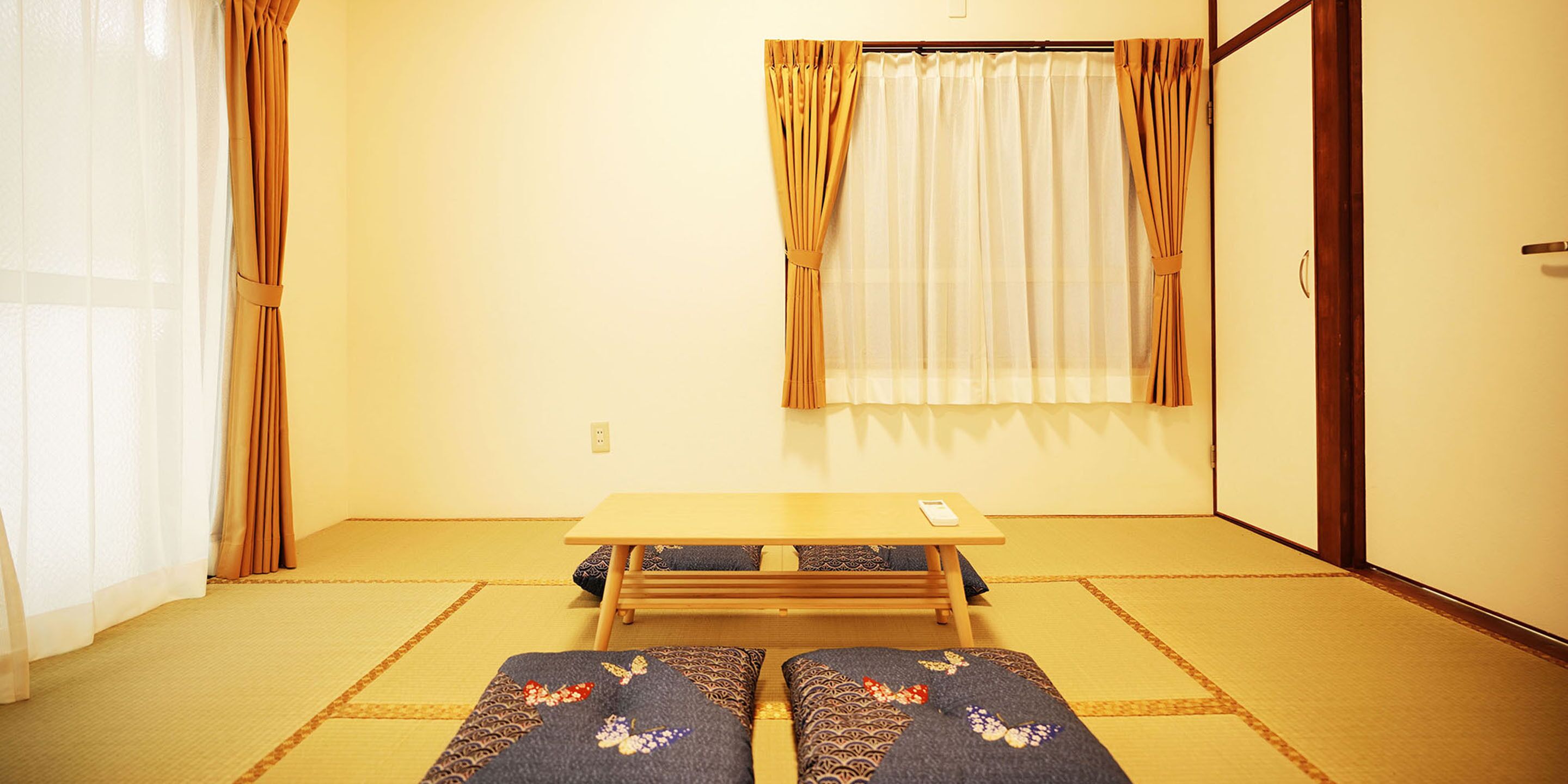 A traditional Japanese room with tatami flooring, a low wooden table, and shoji screens.