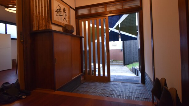 A traditional Japanese interior with tatami flooring, a sliding door, and a wooden cabinet. - Quaint House Naoshima (Naoshima)