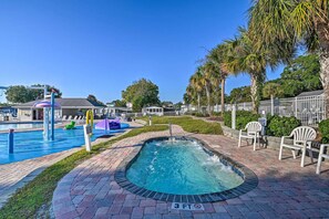 A swimming pool area with a hot tub, lounge chairs, and palm trees. - Our Escape Near the Sea! Limo Golf Cart Included (Garden City)