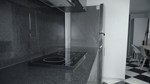 Eine moderne Küche mit schwarzer Granitabdeckung, Edelstahlgeräten und einem Schachbrettboden.