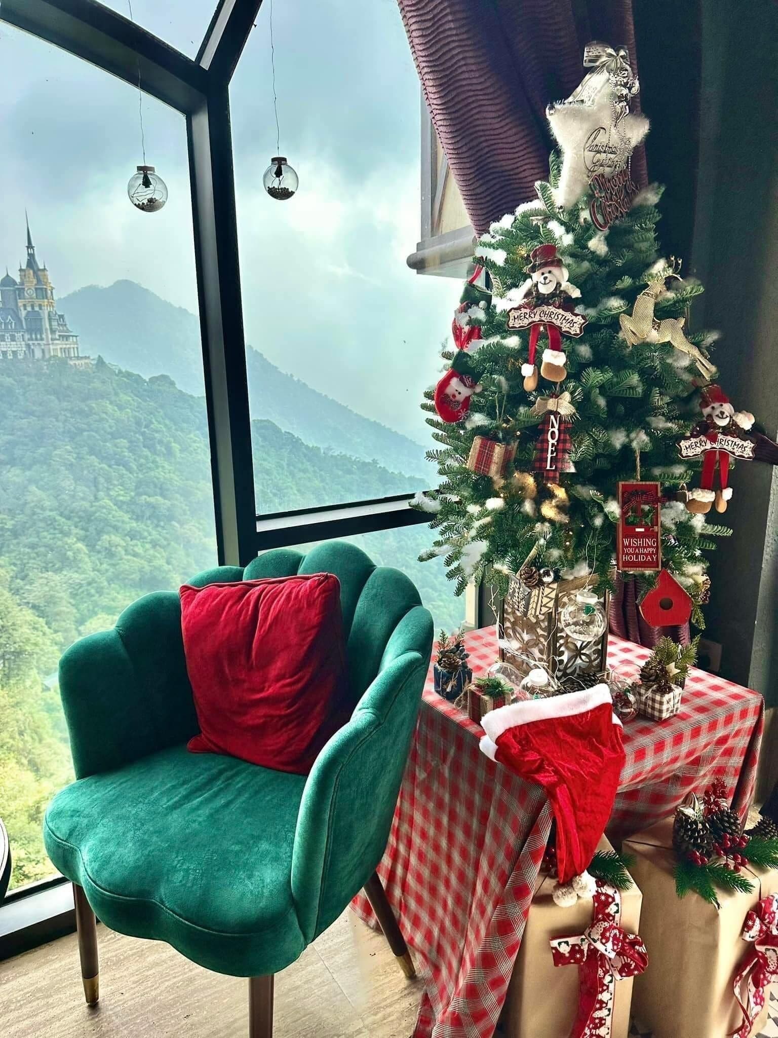 A room with a view of a castle, a Christmas tree, a green armchair, and a table with wrapped gifts.