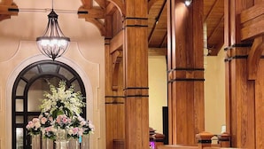 A lobby with wooden architecture, a chandelier, a reception desk, and a floral arrangement. - Venus Hotel Tam Dao (Tam Dao)