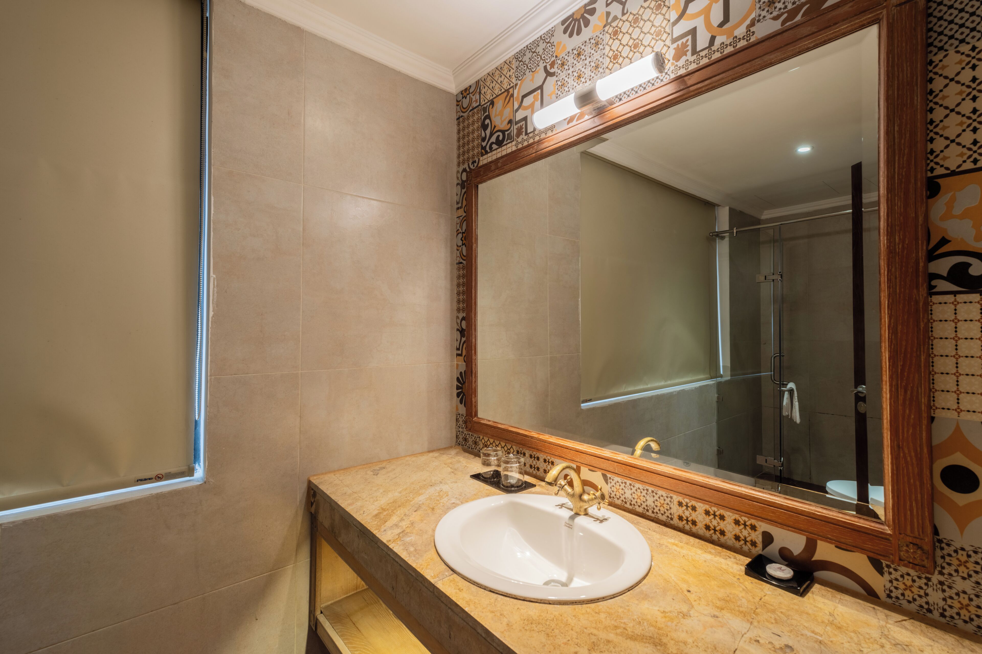 A bathroom with a large mirror, a sink, and a shower.