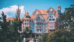 A multi-story building with a traditional architectural style, featuring a prominent tower and multiple windows. - Venus Hotel Tam Dao (Tam Dao)