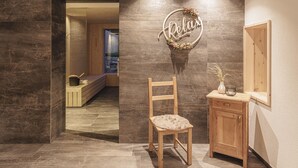 A wooden chair with a cushion, a small wooden cabinet, and a wall-mounted sign that reads 'Relax'. - Silva-Apartments – Apartment "Klausberg" (St.Johann)