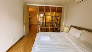Une chambre à coucher avec un lit, une table de chevet et un plancher en bois.