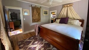 Une chambre à coucher avec un lit à baldaquin, un ventilateur de plafond et un tapis à motifs.