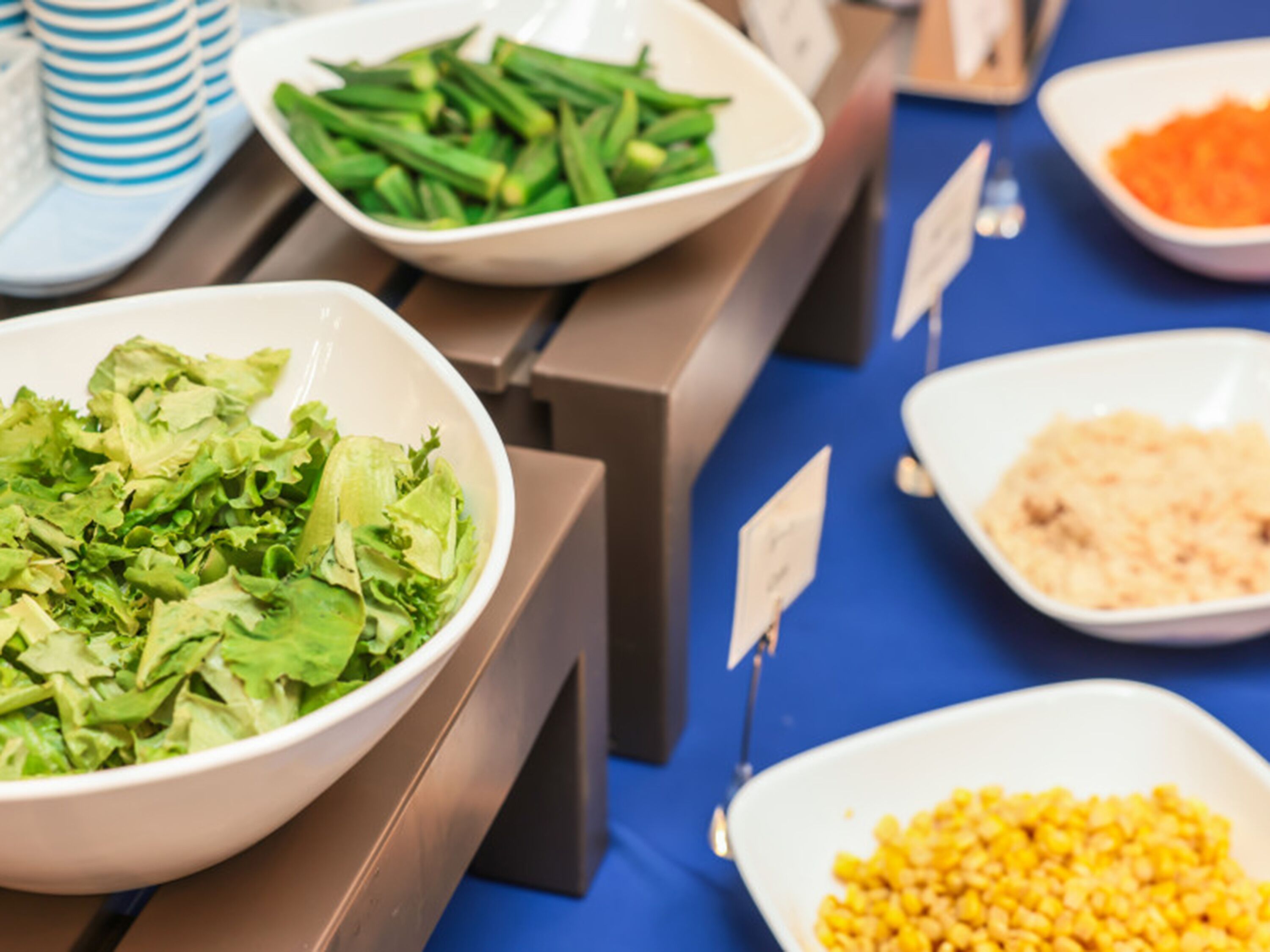 A buffet table with various food dishes including a salad, green beans, and corn.