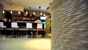 A bar area with white chairs and a counter. - Hotel Terra (Novalja)