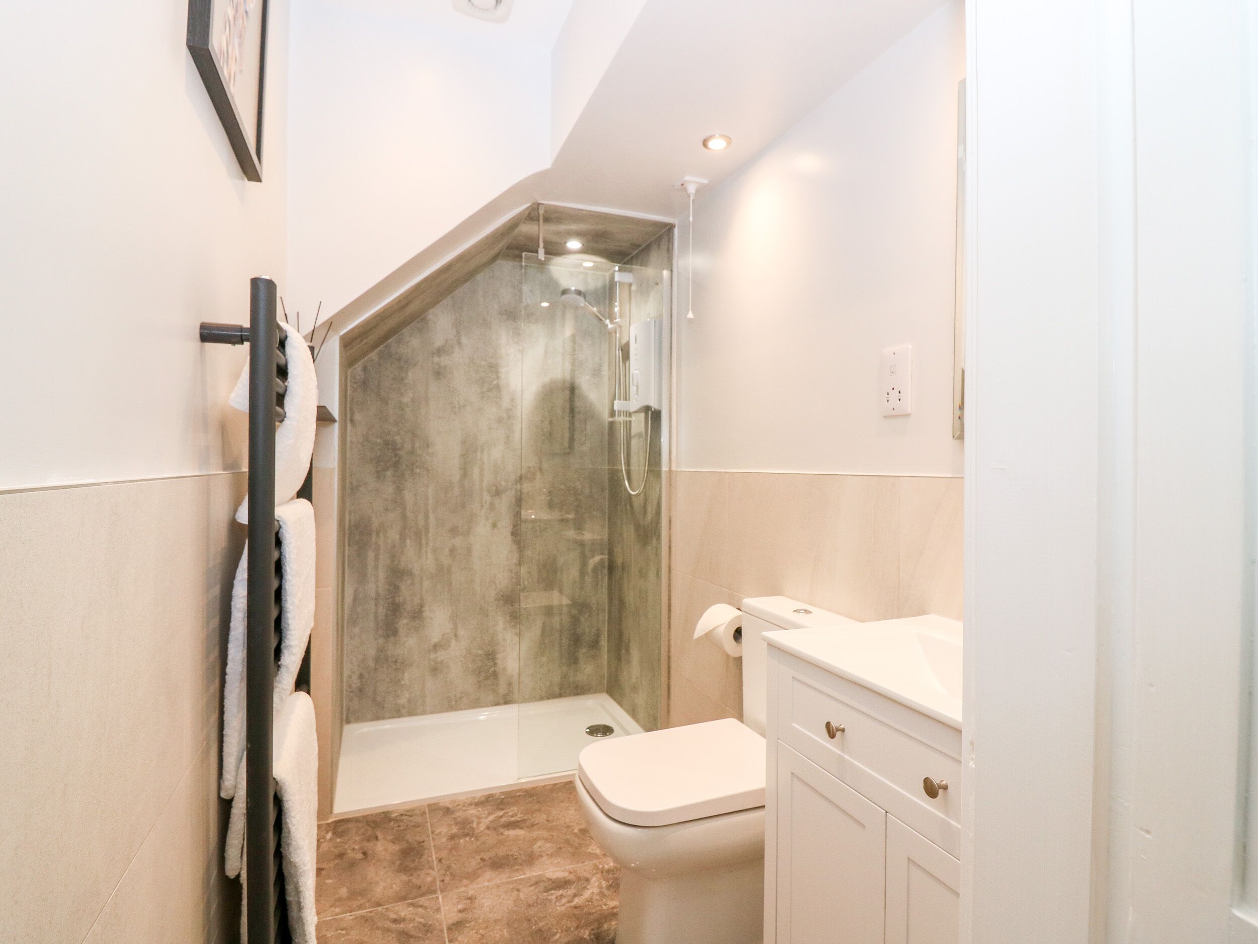 Une salle de bain avec douche, toilettes et lavabo.